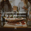 Tisch mit Essen und Wein, im Hintergrund zwei Frauen